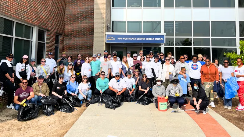 Kind Home Painting volunteers with bagged trash after a Struggle of Love cleanup at KIPP Northeast Denver Middle School